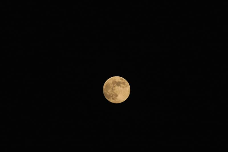 A full moon is seen in the night sky