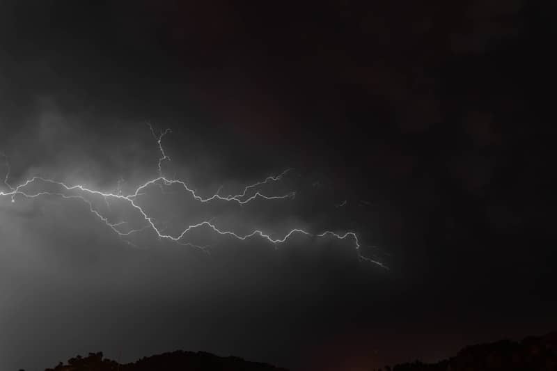 A dark sky with a lightning bolt in the middle of it