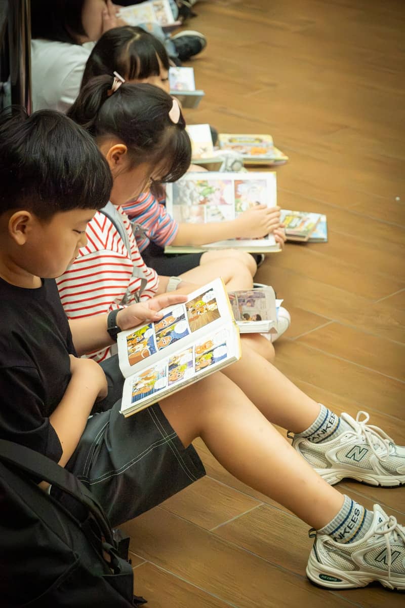 Children reading books together on the floor.