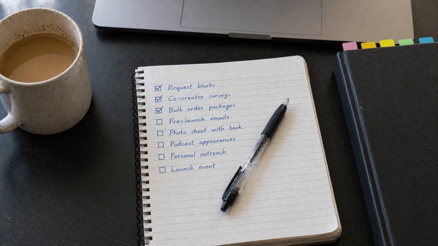 Handwritten launch checklist on a notebook beside a coffee mug