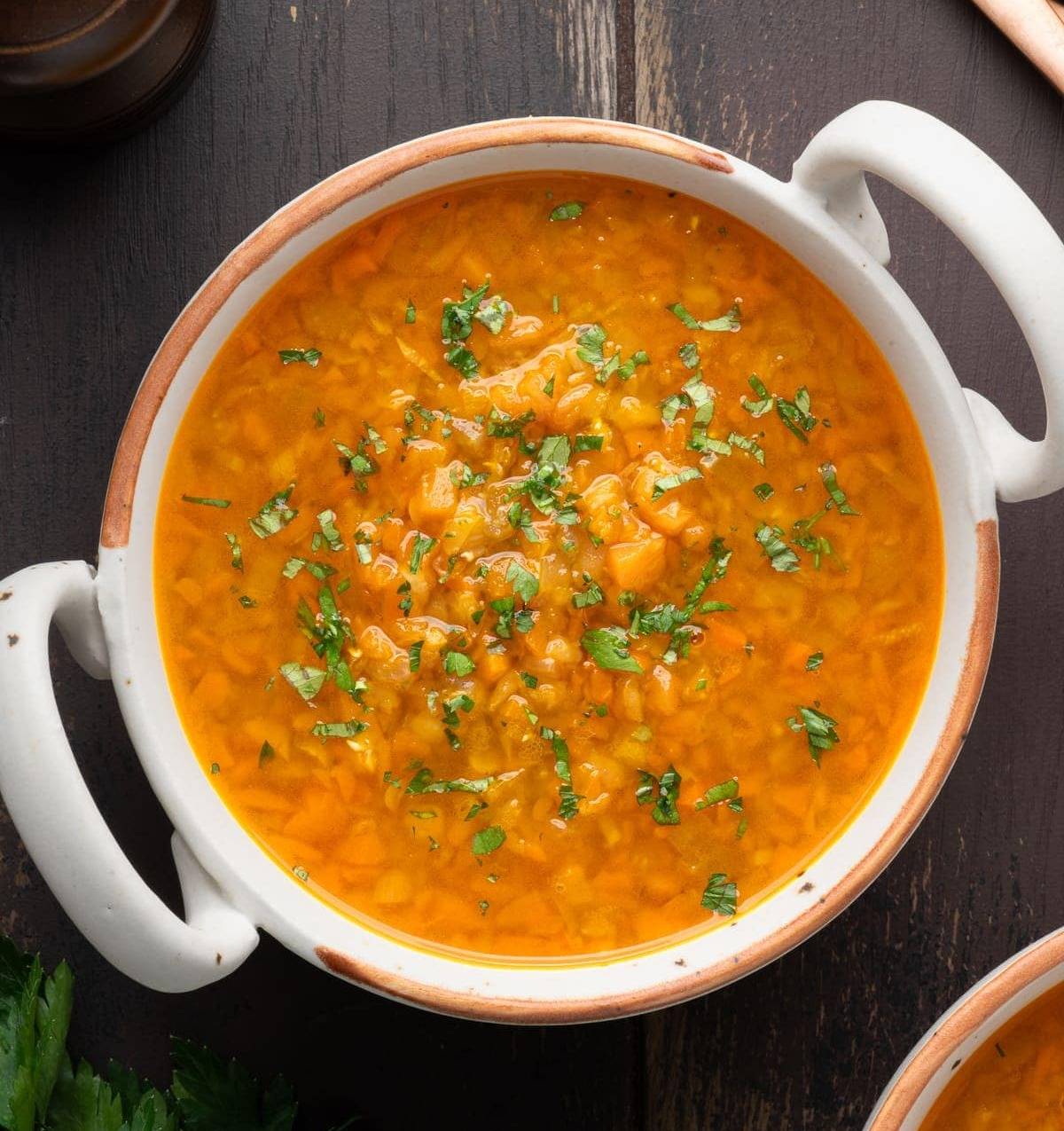 overhead view of a large pot of carrot and lentil soup