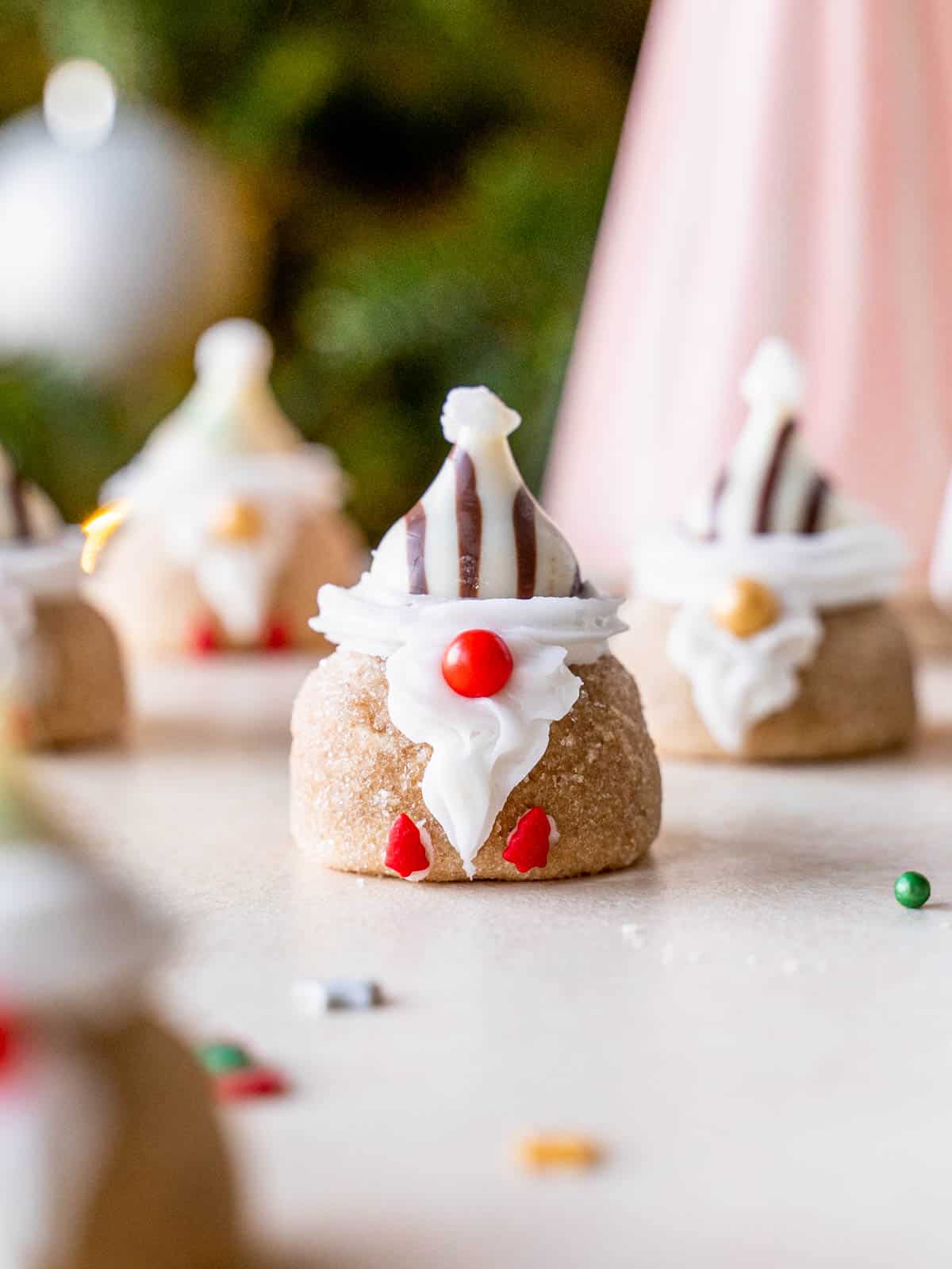 A peanut butter blossom cookies shaped like a gnome with a red nose.
