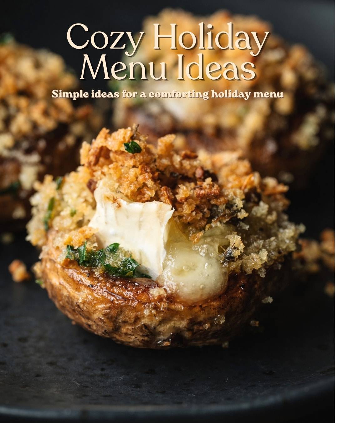 A brie-stuffed mushroom with melting cheese on a black slate serving board. Text overlay says "Cozy Holiday Menu Ideas".