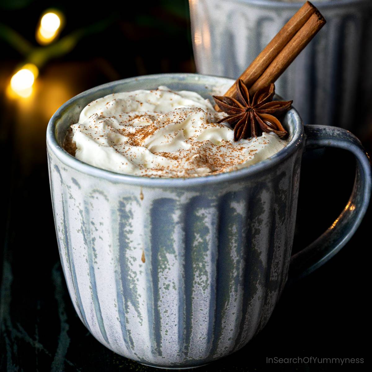 A cup of hot spiced chocolate topped with whipped cream and cinnamon.