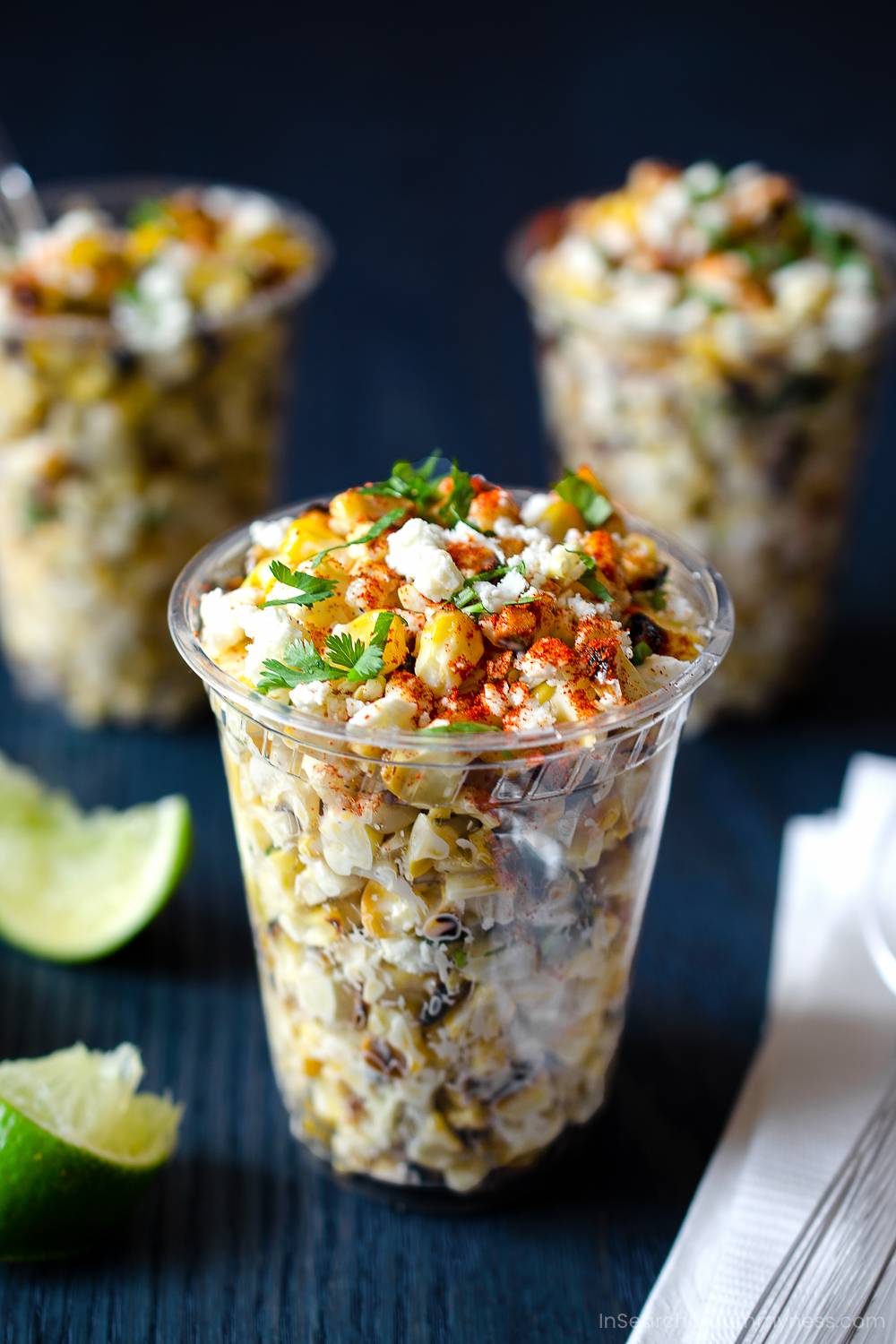 Clear cups filled with seasoned corn.