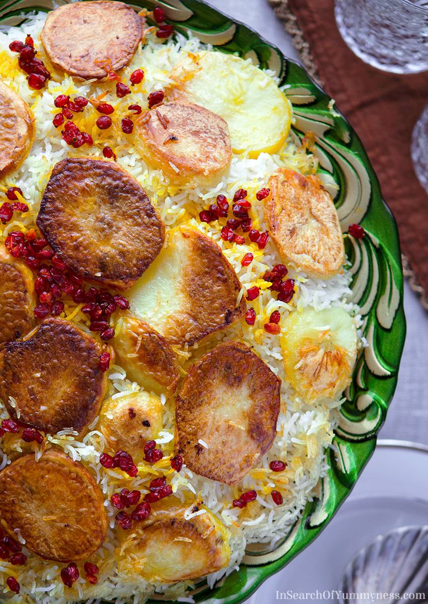 An ornante green plate full of cooked potato tahdig rice.