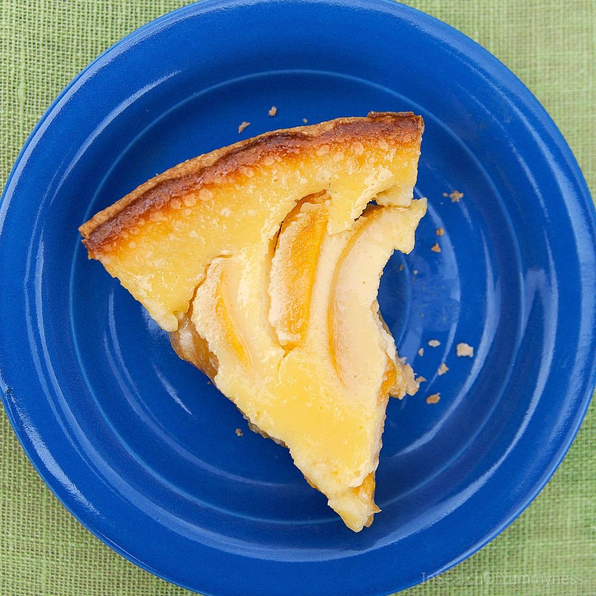 A slice of sour cream peach pie on a blue plate.