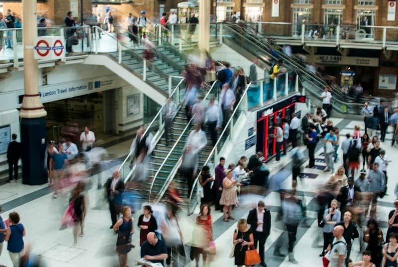 Commuters in motion on escalators and a concourse at Liverpool Street station in London