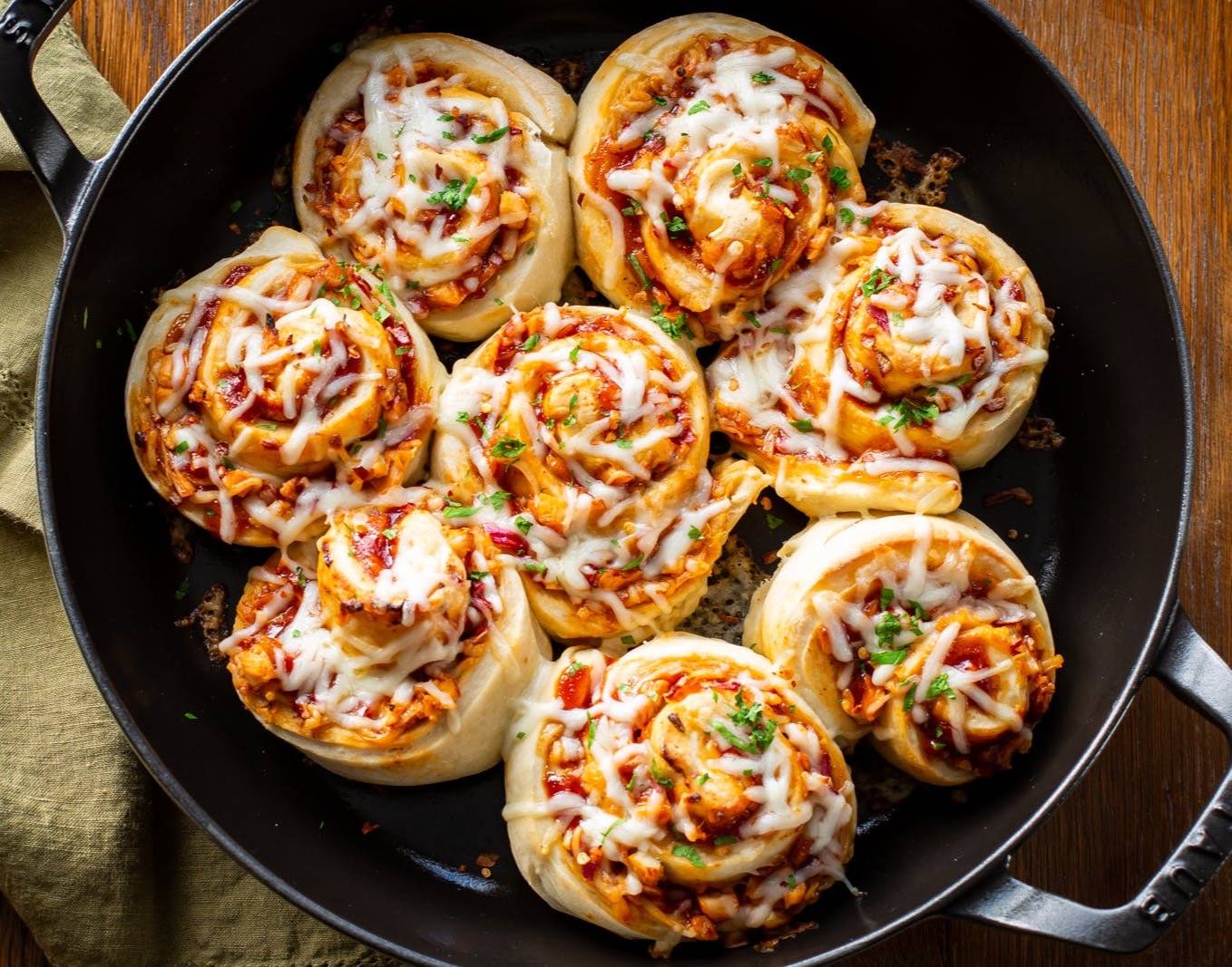 An overhead view of a skillet filled with pizza rolls
