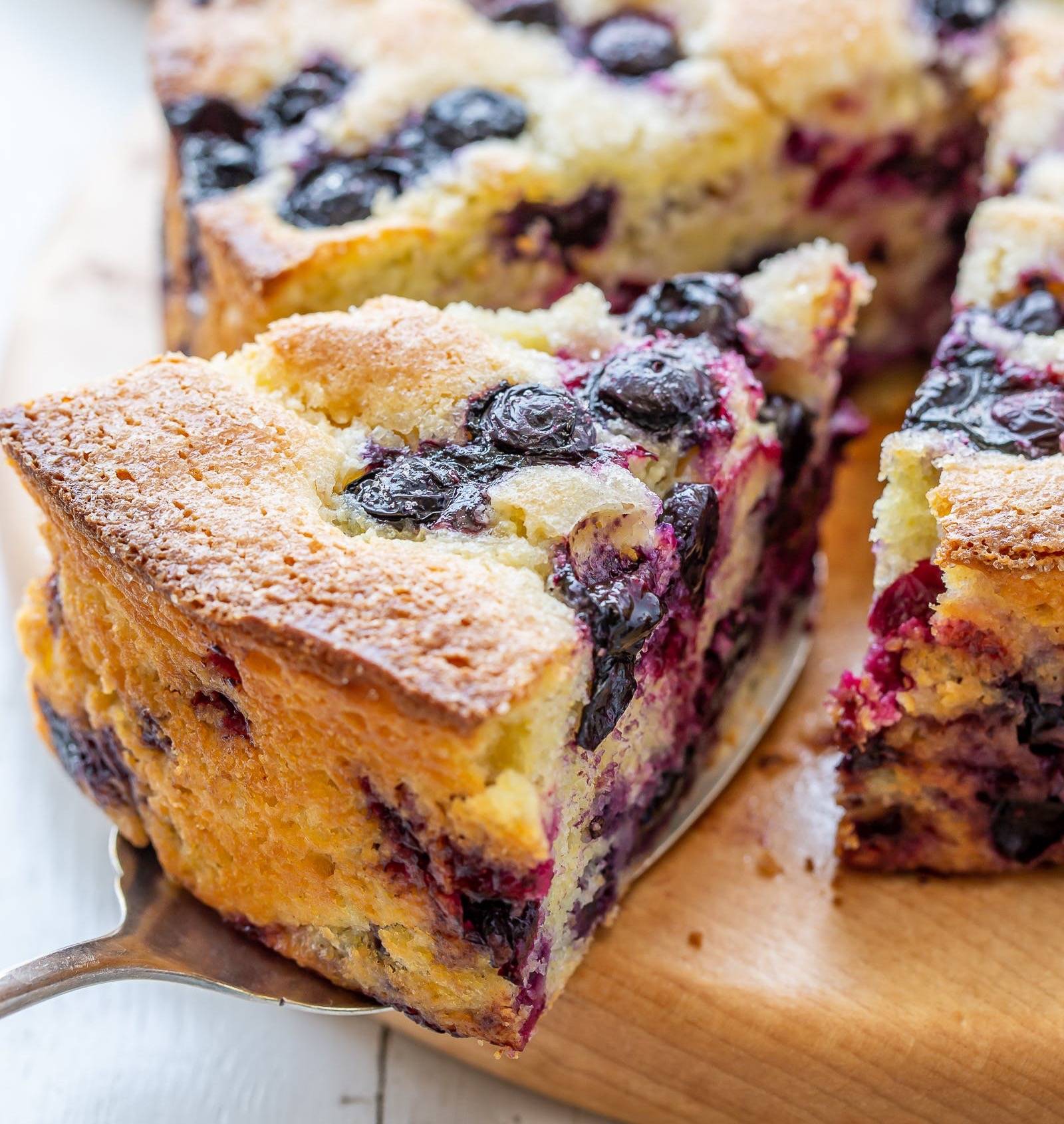 A slice of blueberry cornbread on a cutting board