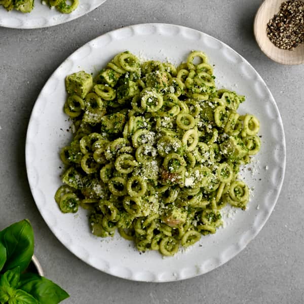 Pesto pasta salad with chicken on a dinner plate.