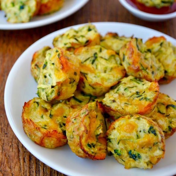 Cheesy baked zucchini tots on a plate.