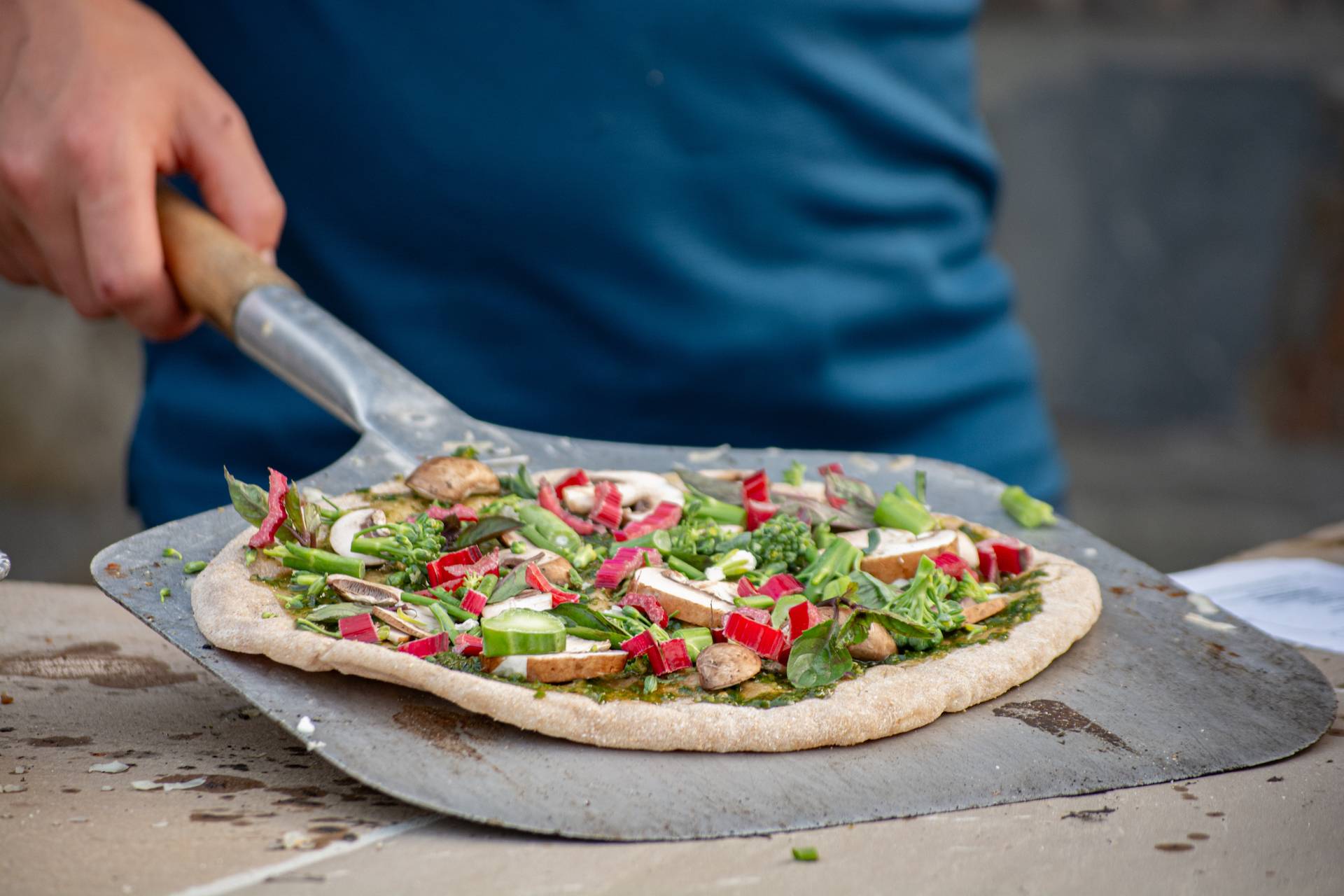Amazing farm to table pizza ready to go into the brick oven. Ok, slide it off the peal now.