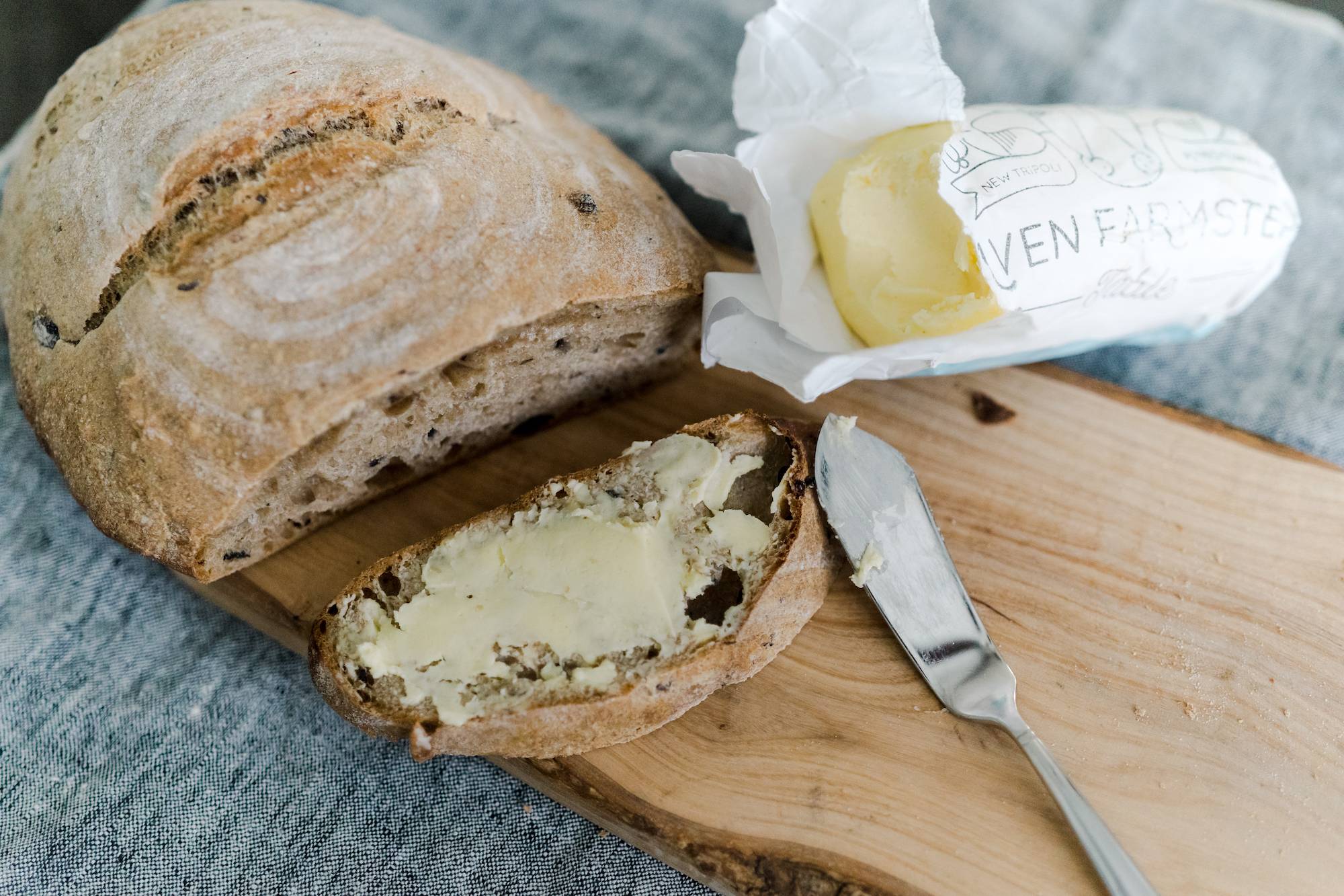 Fresh, organic sourdough bread sliced with grass fed butter.