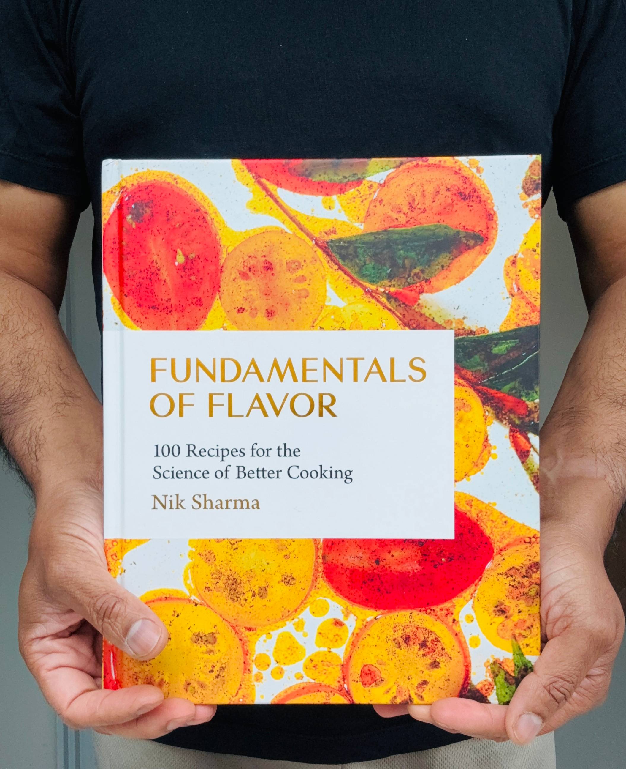 Nik Sharma holding Fundamentals of Flavor, his new cookbook on the science of better cooking.