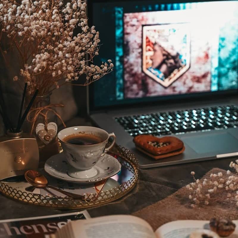 Cozy setup with a laptop, coffee, and snacks.