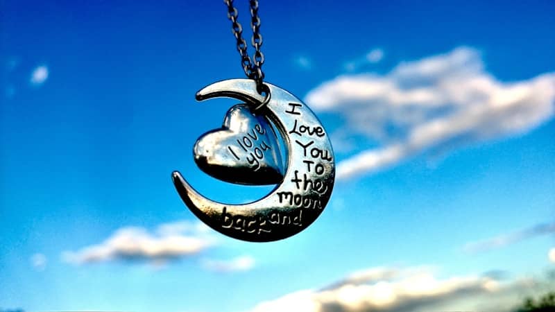 A crescent with a heart hanging from it