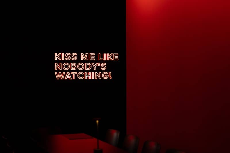 A dark room with a neon sign on the wall