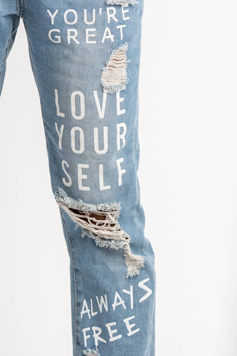 A pair of ripped jeans with words written on them