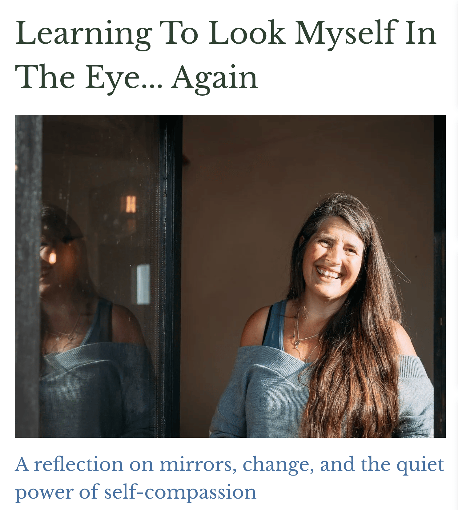 Henny smiling, looking at the camera, reflected in a glass door