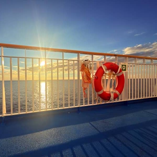 Life preserver on a ship railing at sunset