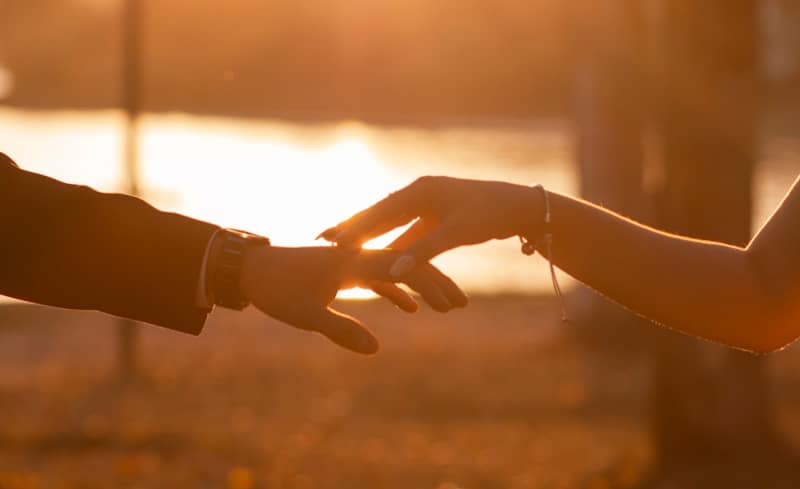 Couple holding hands at sunset