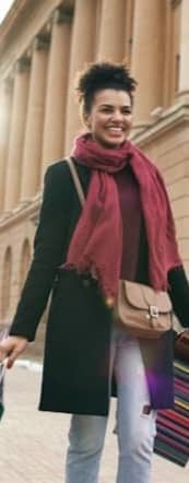 Woman walking with shopping bags outside building