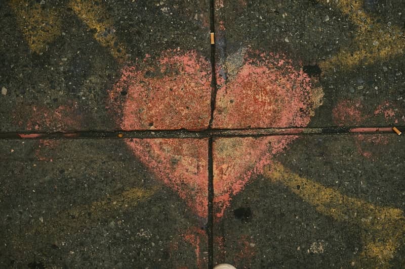 Chalk heart drawn on cracked pavement