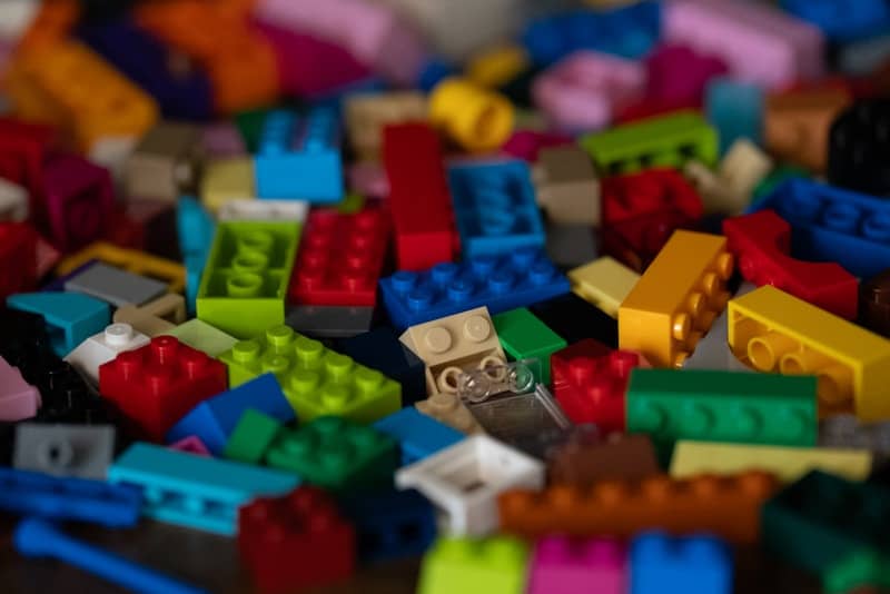 A pile of colorful building blocks scattered on a surface.
