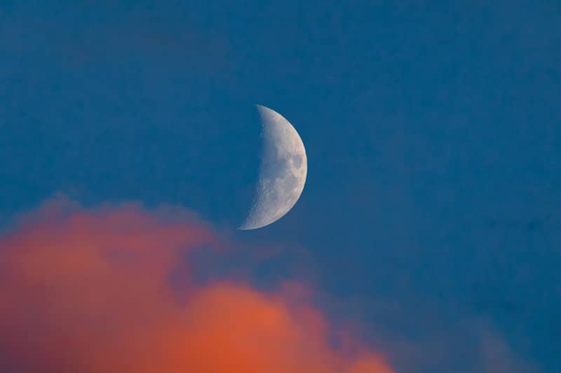 Crescent moon partially obscured by clouds