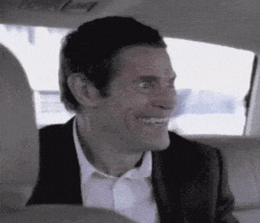 A gif of actor Willem Dafoe with a wide, terrifying grin. The camera zooms in on his face dramatically as he opens his mouth to laugh.