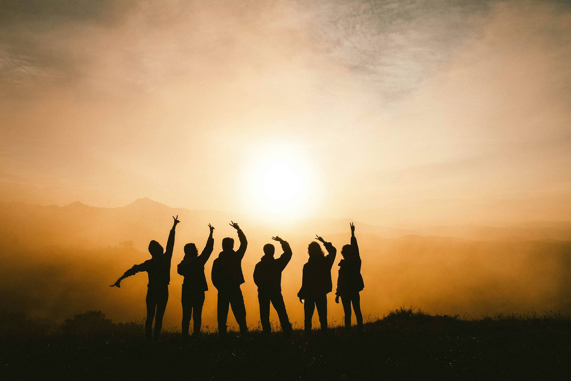 6 friends silhouettes facing the sun