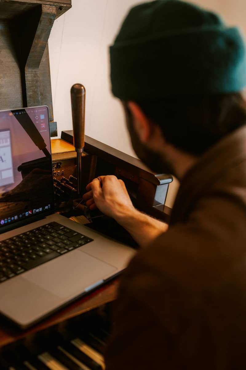Man working on a laptop and an old machine