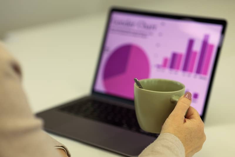 Person working on a laptop with a cup of coffee.