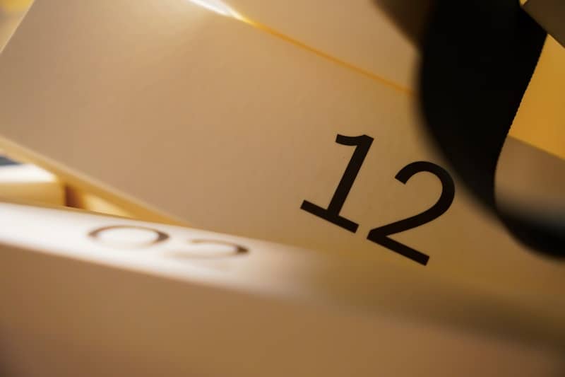 Close-up of the number 12 on a white surface.