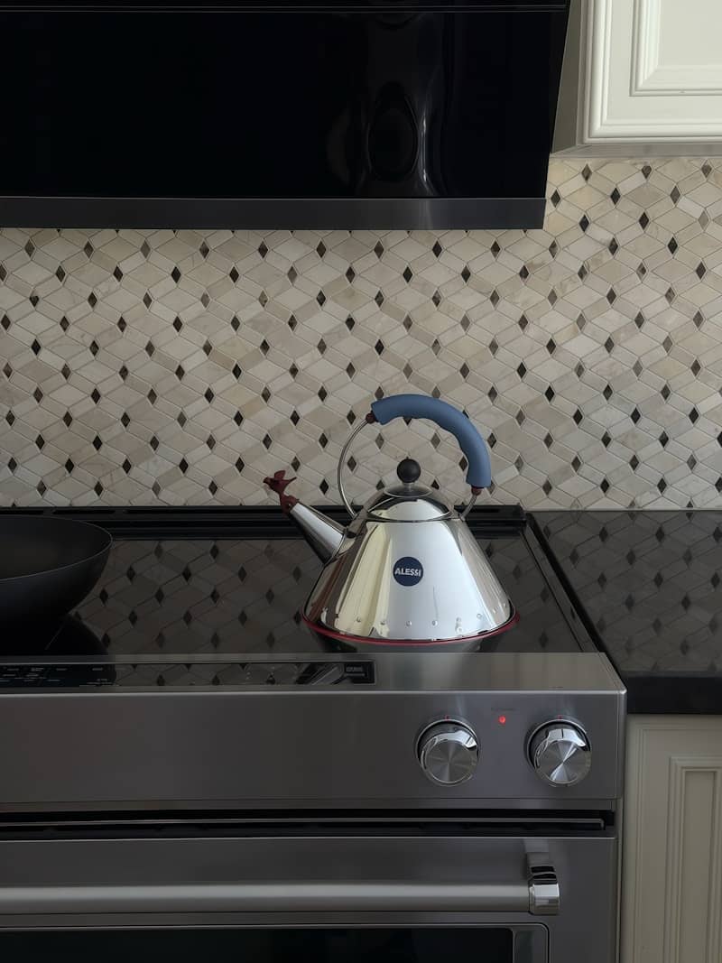A stovetop kettle sits on a modern kitchen range.
