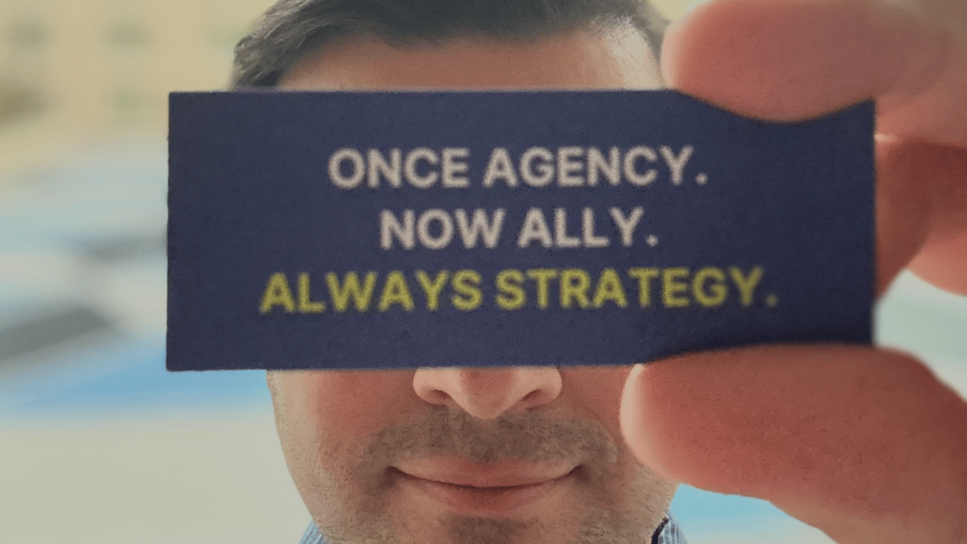 Dan holding a card that says "Once Agency. Now Ally. Always Strategy."