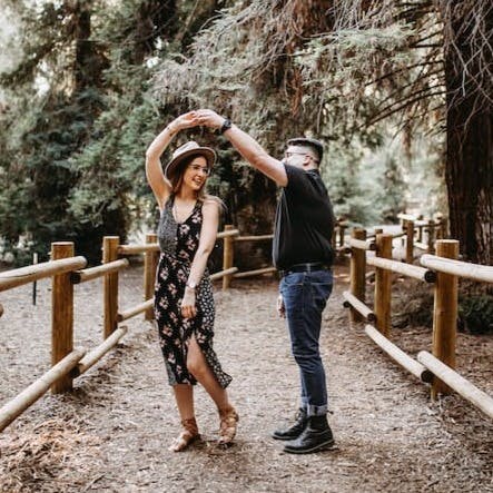 man and woman dancing between brown wooden handrails