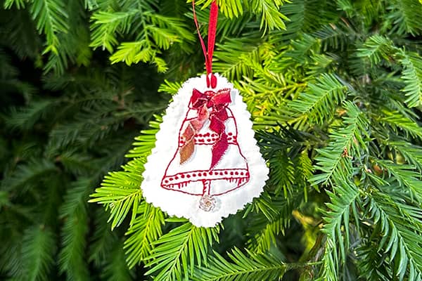 Redwork embroidered Holiday Bell with ombre red/brown/cherry ribbon and a vintage clear glass button flower for the bell.