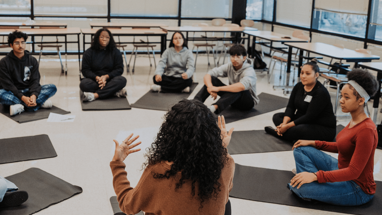 Woman using laptop while sitting under a tree