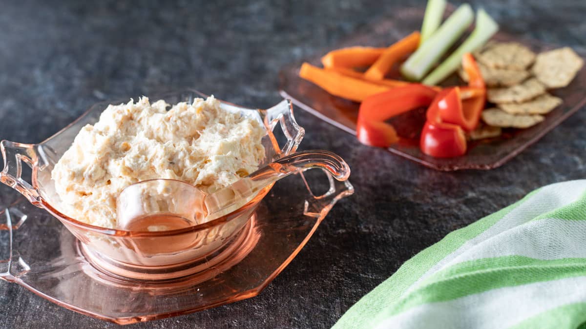 Shrimp dip in a pink depression glass bowl.