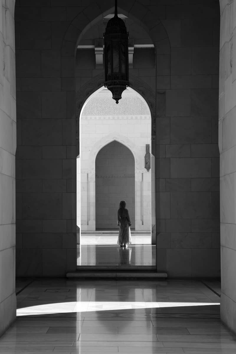Silhouetted figure in archway with overhead lantern