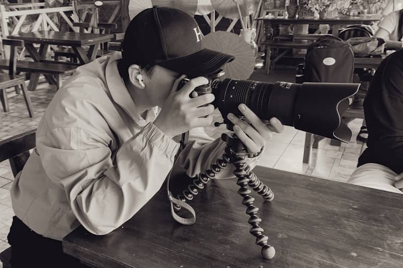 Man with cap taking photo with dslr camera
