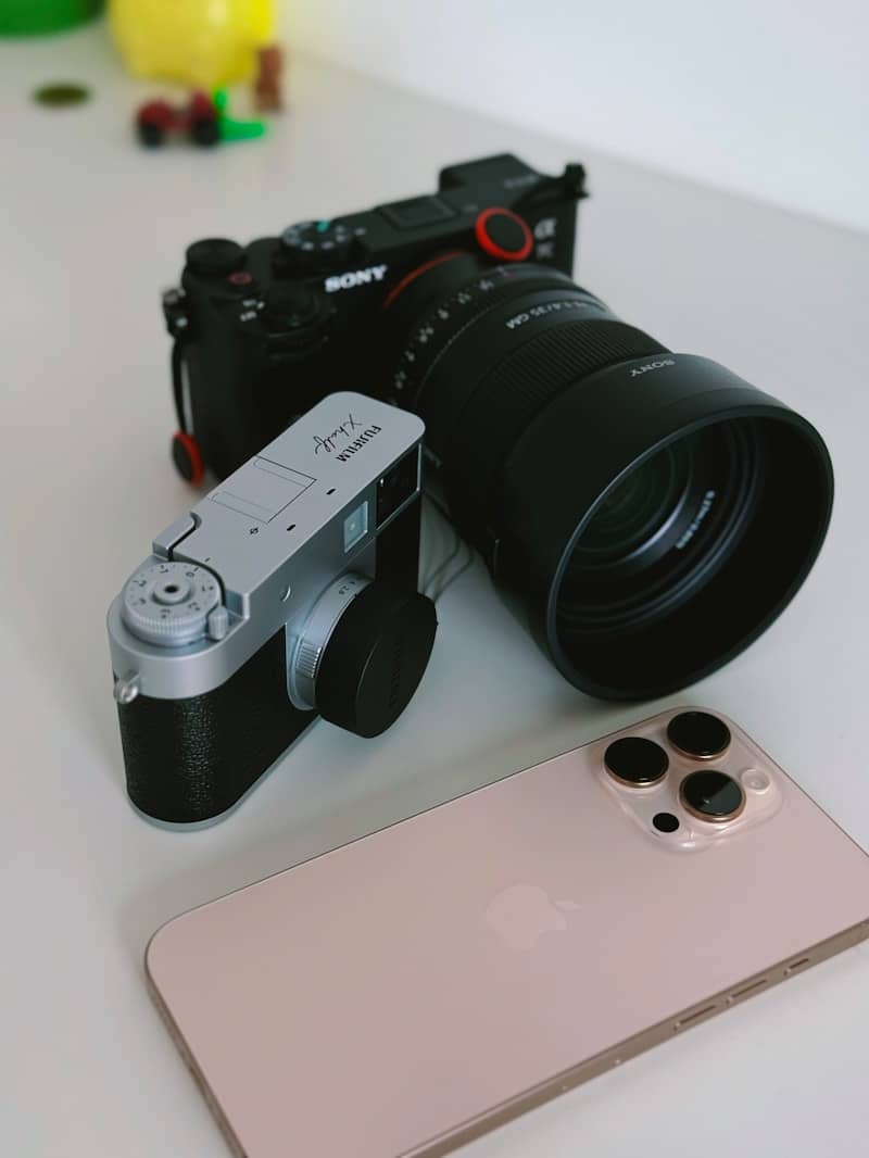 Cameras and phone sit on a bright white surface.
