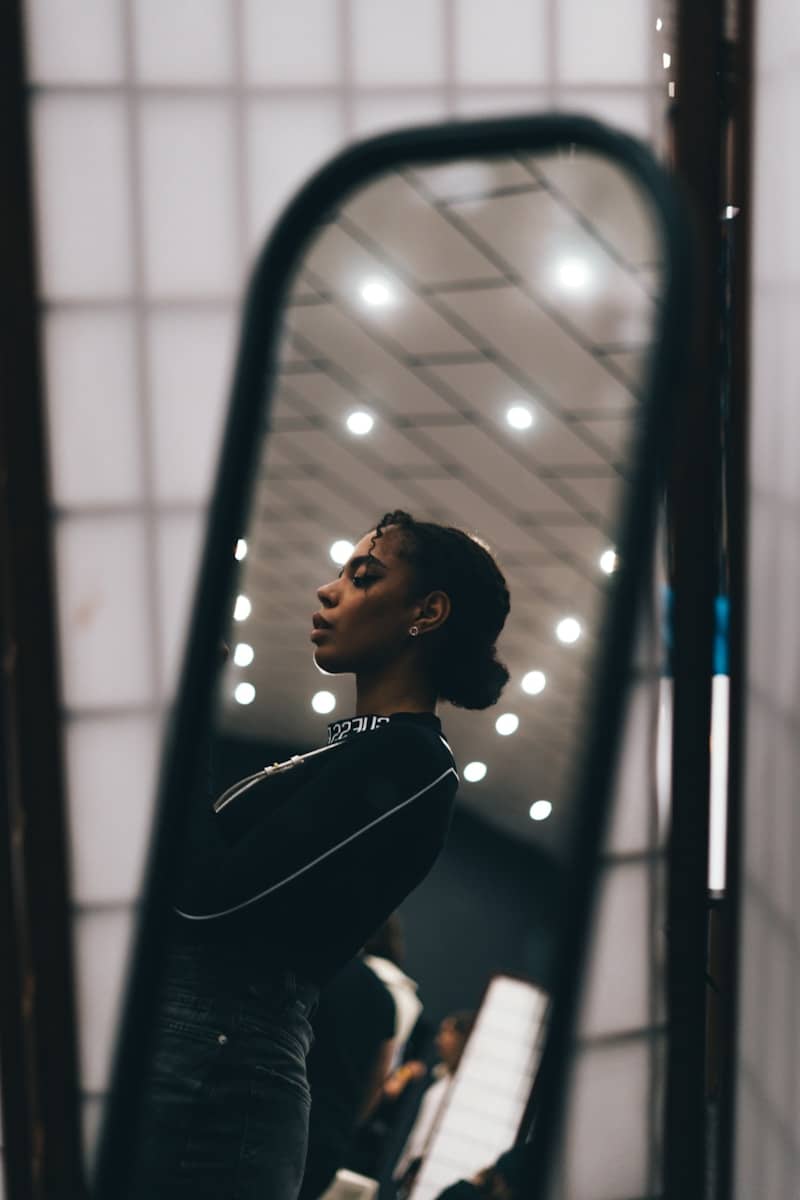 a woman standing in front of a mirror