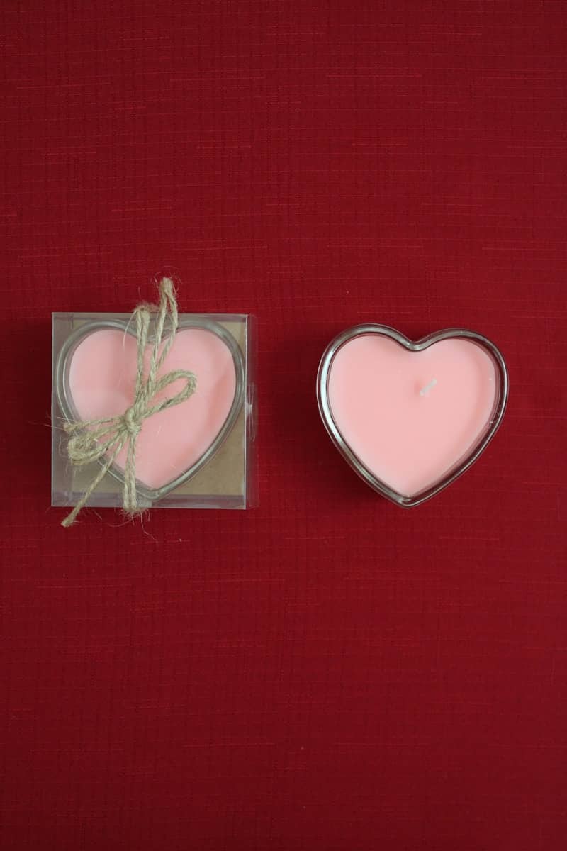 Two heart shaped candles sitting next to each other