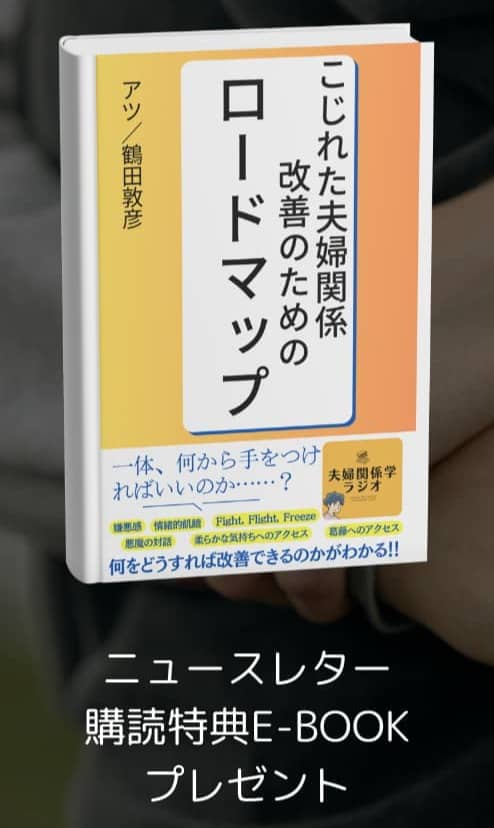 A person is holding a book with a Japanese title that translates to 