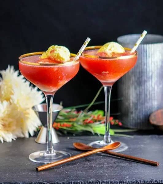 Two drinks in stemmed glasses with a scoop of ice cream in each.