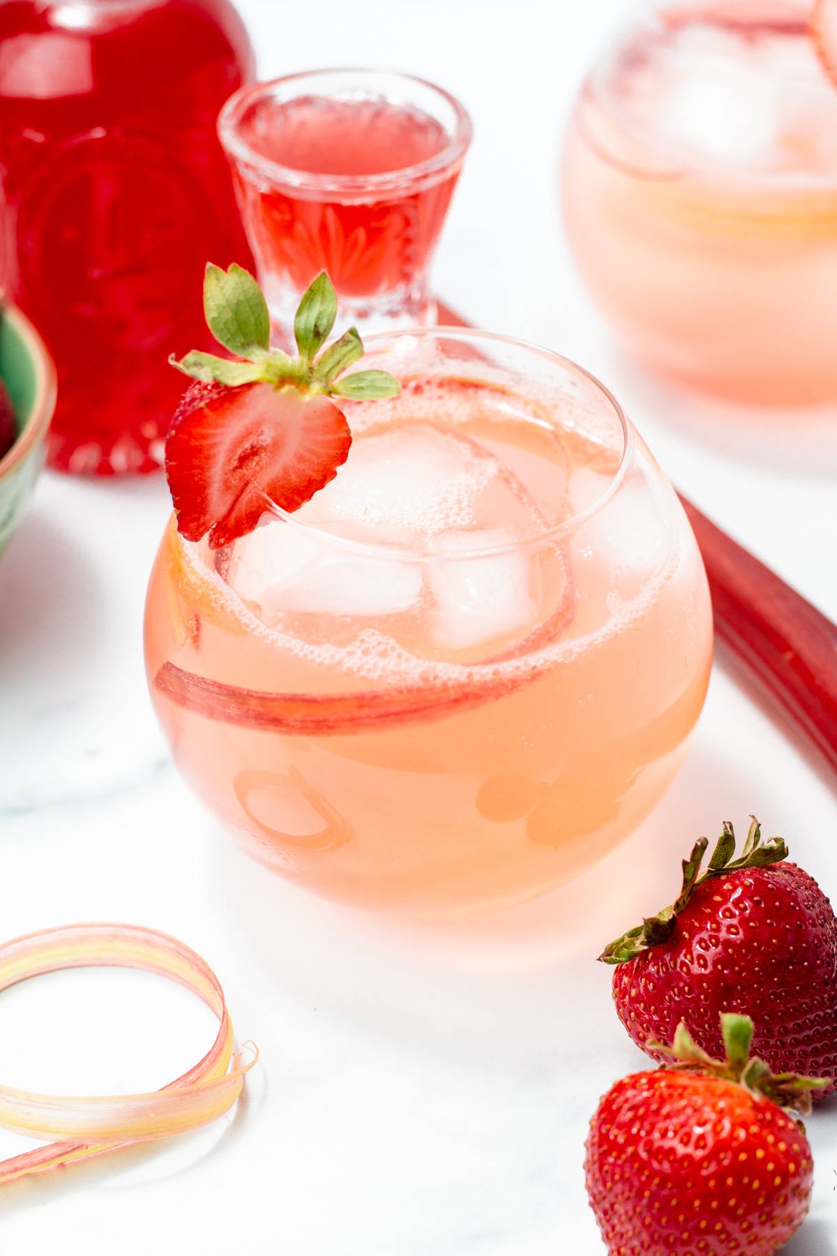 A pale pink drink with strawberries and rhubarb.