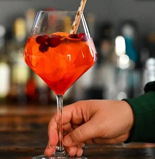 A red drink in a stemmed glass.